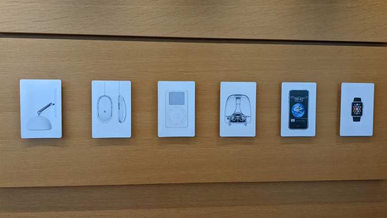 Artwork of an iMac, Apple mouse, iPod, original iMac, iPhone, and Apple Watch on the wall of the Apple Visitor Center in Cupertino.