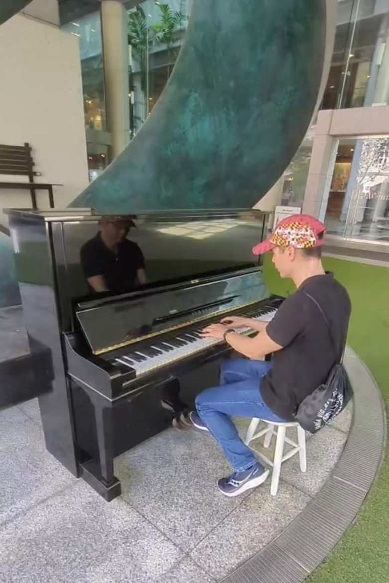 Felix playing the piano outside the Singapore City Gallery museum. 