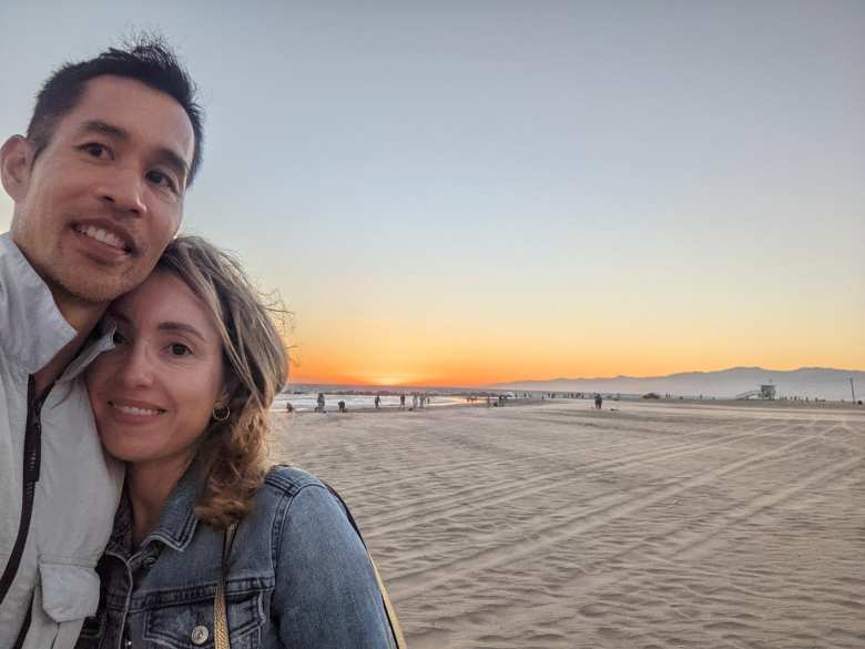 Felix and Andrea in front of a sunset at Venice Beach.