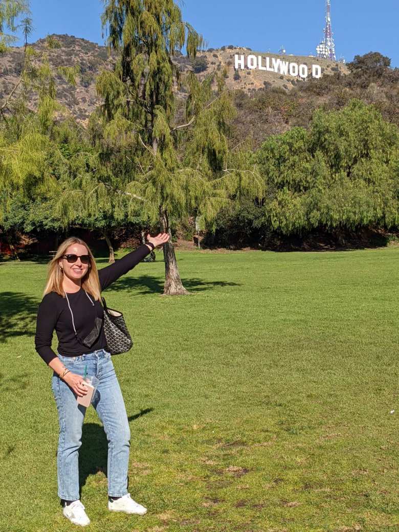 Andrea at Lake Hollywood Park pointing to the iconic Hollywood sign.