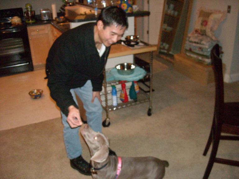 Felix Wong feeding Dan and Susan's dog Beatrice a Scooby snack.