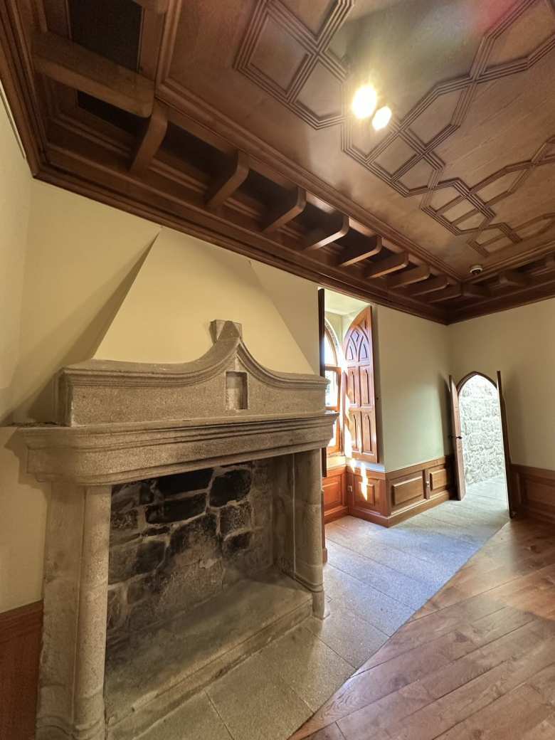 A room with a fireplace and wood ceiling.