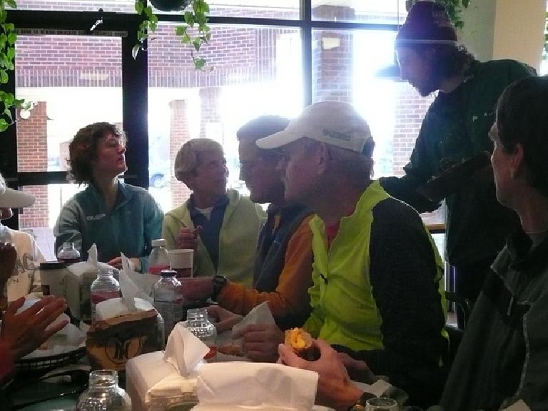 Jen Sajbel, Cathy Morgan, unknown person, Tom Schipper, Nick Clark, and unknown person sitting around a table