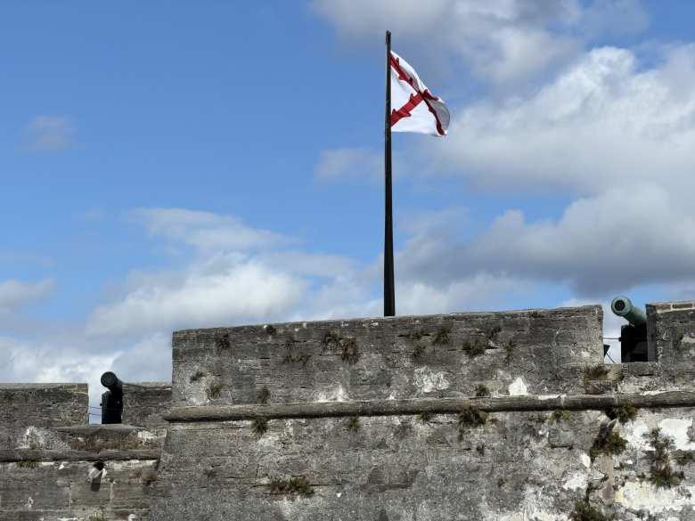 Cannons on the castle walls with a historical Spanish ensign flag.