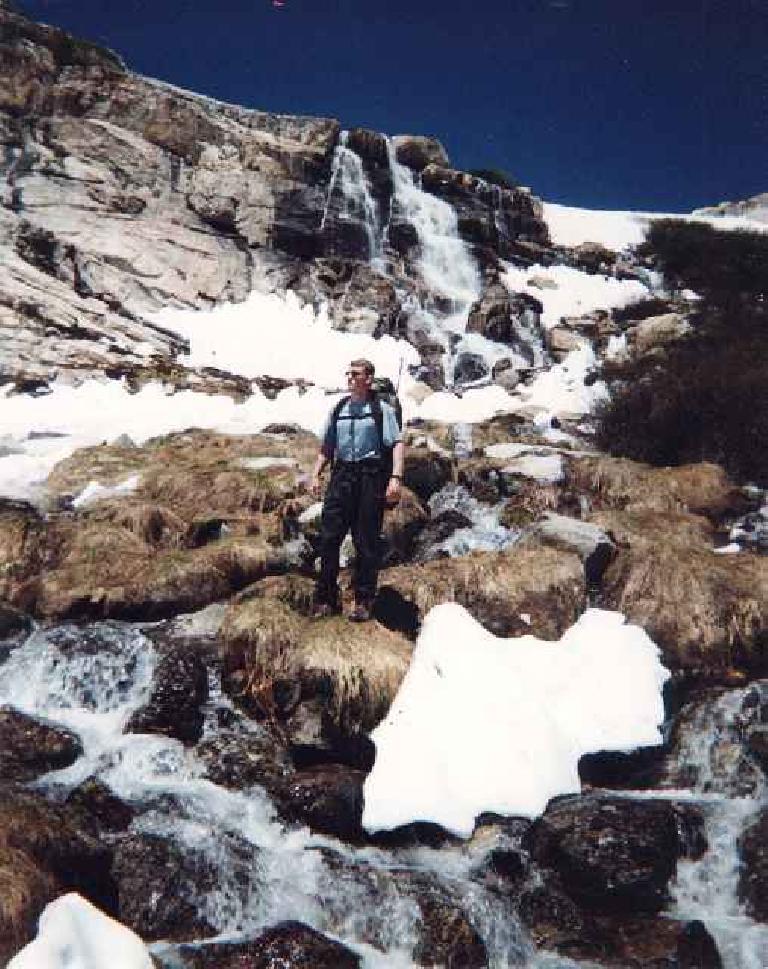 Stephen Cook in blue shirt wearing backpack at Mt. Conness.