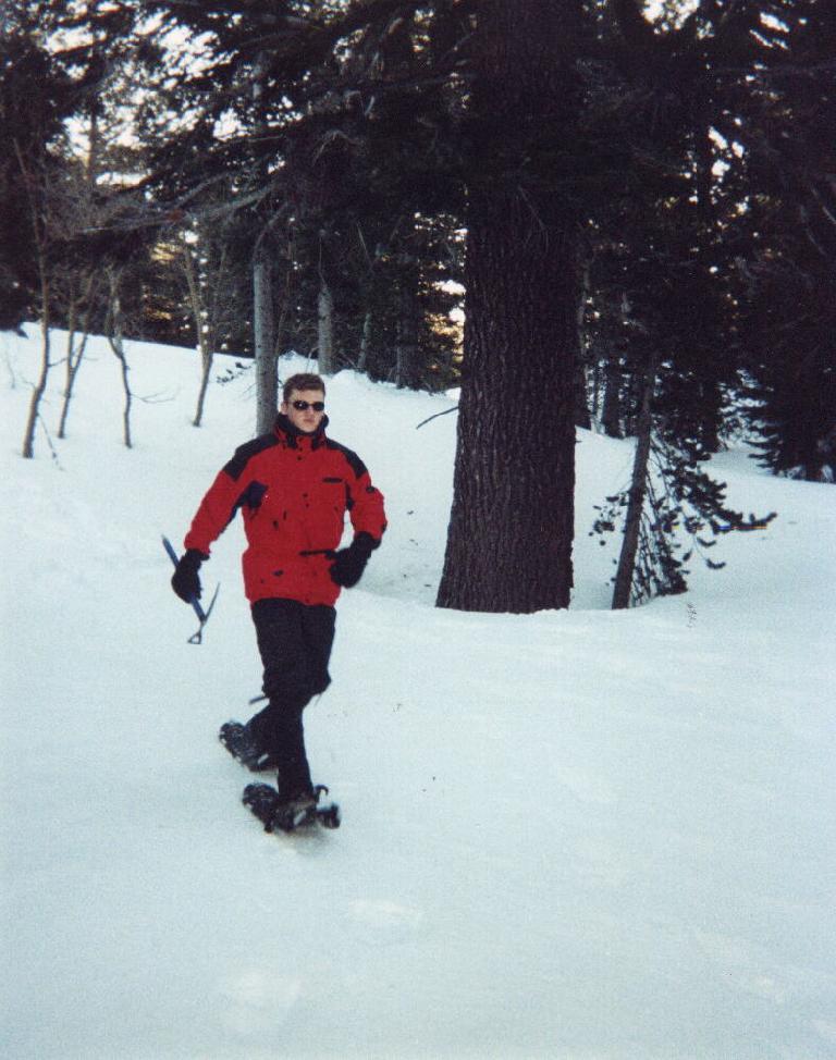 Stephen Cook in a red jacket snowshoeing.