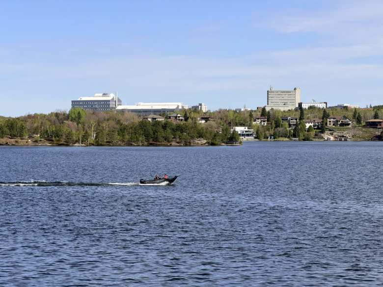 A speedboat glides by Laurentian University on Ramsey Lake. A speedboat glides by Laurentian University on Ramsey Lake.