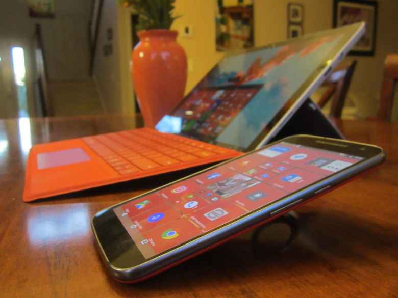 red Moto G4 with SquareHome 2 and ring stand, red Microsoft Surface Pro 4