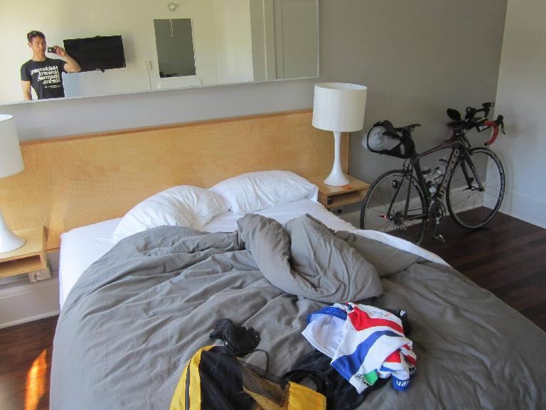 Cycling clothes on bed and black Litespeed Archon C2 in cabin room of Norblad Hotel in Astoria, Orego.