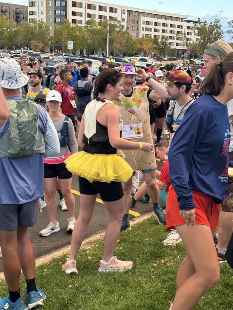 A woman in a yellow skirt and guy in a outfit that looked like a taco.