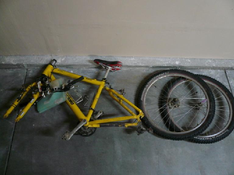 yellow 1996 Cannondale F700 bicycle on garage floor with wheels flat on the ground to the right of it