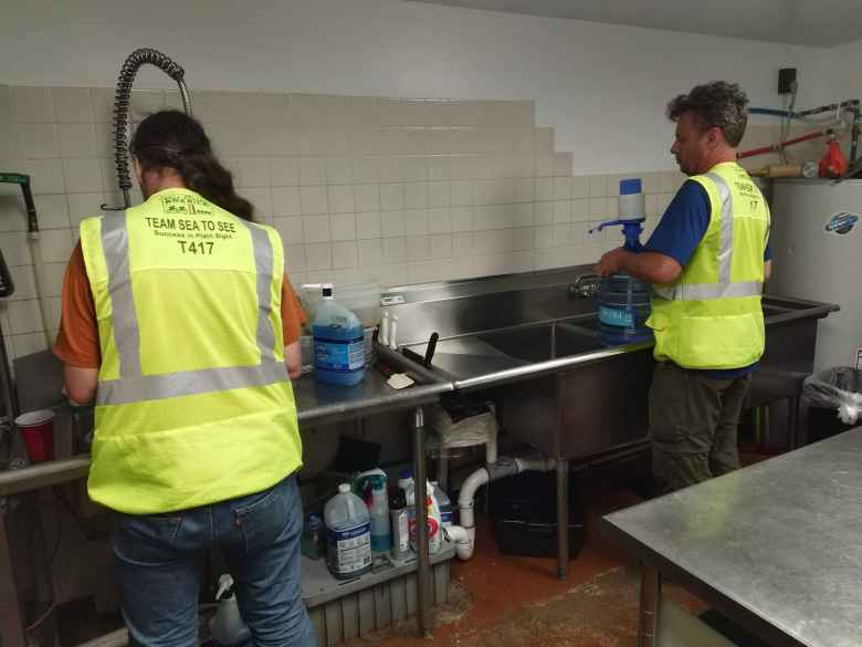 Matt Hannifin and Nate Faudel (both RV drivers for Team Sea to See) helping wash dishes inside the kitchen of a random restaurant in Pagosa Springs.