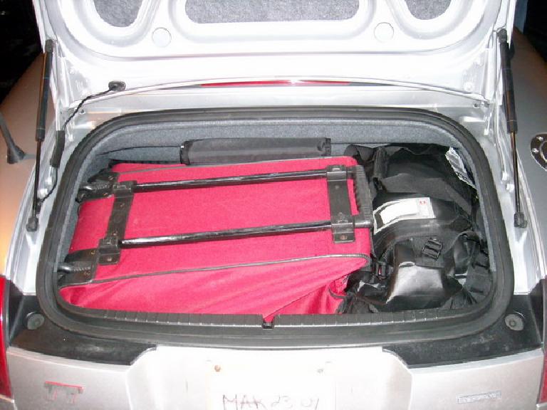 red suitcase and black backpack inside the trunk of a 2001 Audi TT Roadster