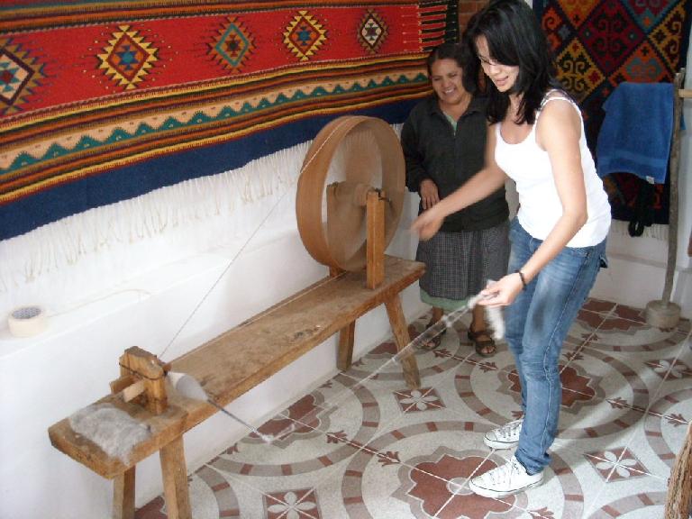 Ojudju trying to spin yarn on a spinning wheel.  It was harder than it looks.