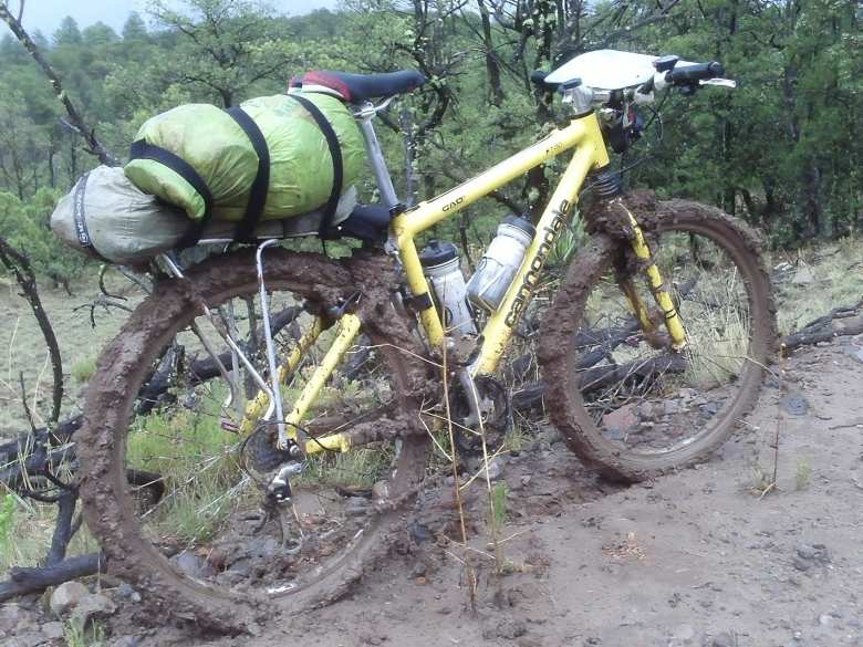 yellow Cannondale F700 covered in mud and loaded with bikepacking gear in New Mexico during the 2008 Tour Divide mountain bike race