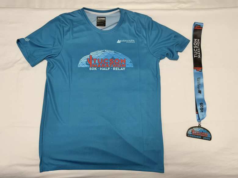 The 2025 Tucson Marathon T-shirt and finisher's medal.