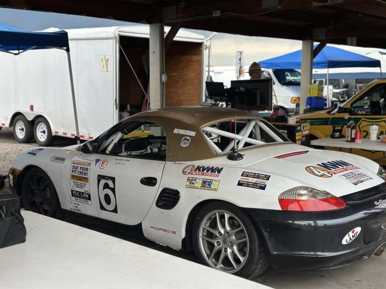 A white first-generation Porsche Boxster with lots of lawyer stickers attached. A white first-generation Porsche Boxster with lots of lawyer stickers attached.