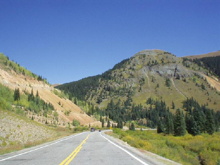 Dirt mountainsides and a butte ahead.