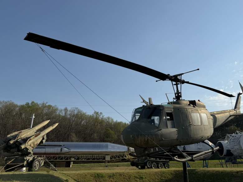 There is some military equipment outside , such as a missile launcher and helicopter.