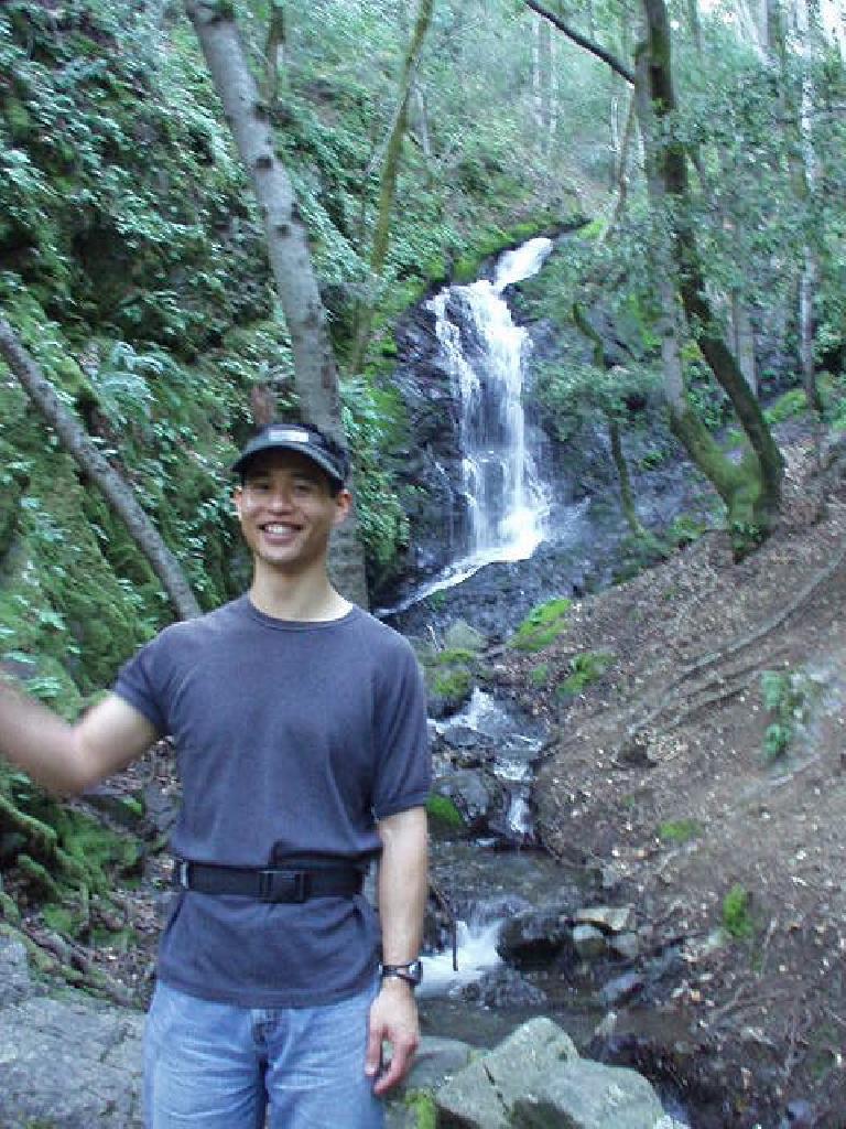 Felix Wong gives a wave in front of the same waterfall.
