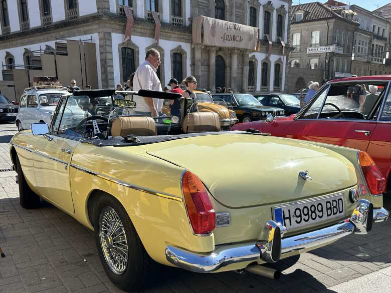 The left rear view of the Pale Primrose Yellow MGB roadster with wire wheels at the car show in Pontevedra.