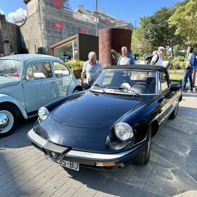 A black Alfa Romeo Spider from the 1980s.