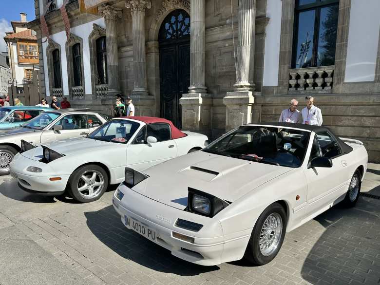 An off-white second-generation Mazda RX-7 convertible and white first-generation Mazda MX-5 Miata.