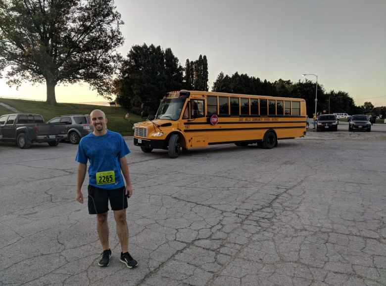 Manuel with one of the yellow school buses that took runners to the start of the 2019 Wabash Trace Trail Marathon.