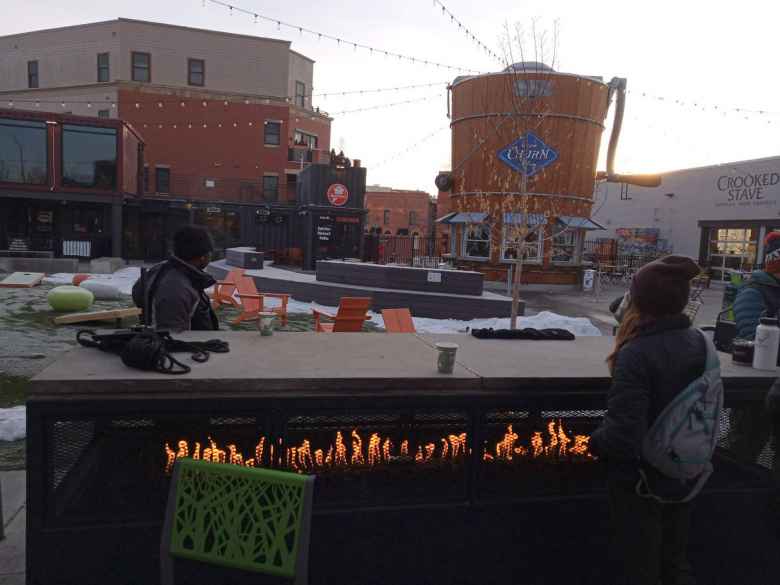 Brooke warming up by the fire at the Exchange in Old Town Fort Collins during Winter Bike to Work Day.