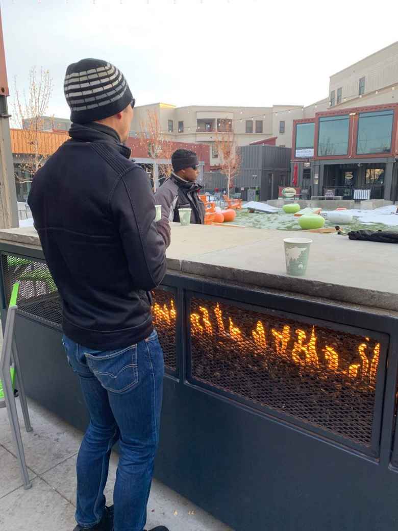 Felix warming up by the fire at the Exchange in Old Town Fort Collins during Winter Bike to Work Day.